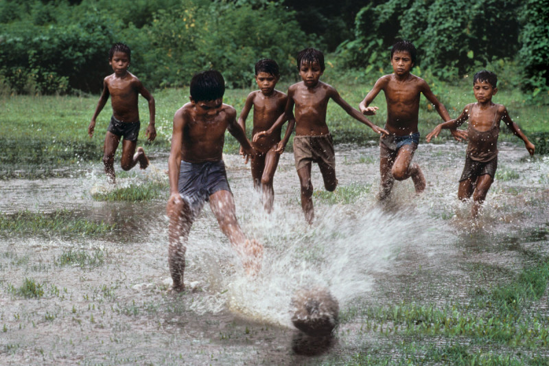 Fotó: Steve McCurry / Boys playing soccer in the flooded pastures, Bangladesh, 1983 / Photoshop: ?