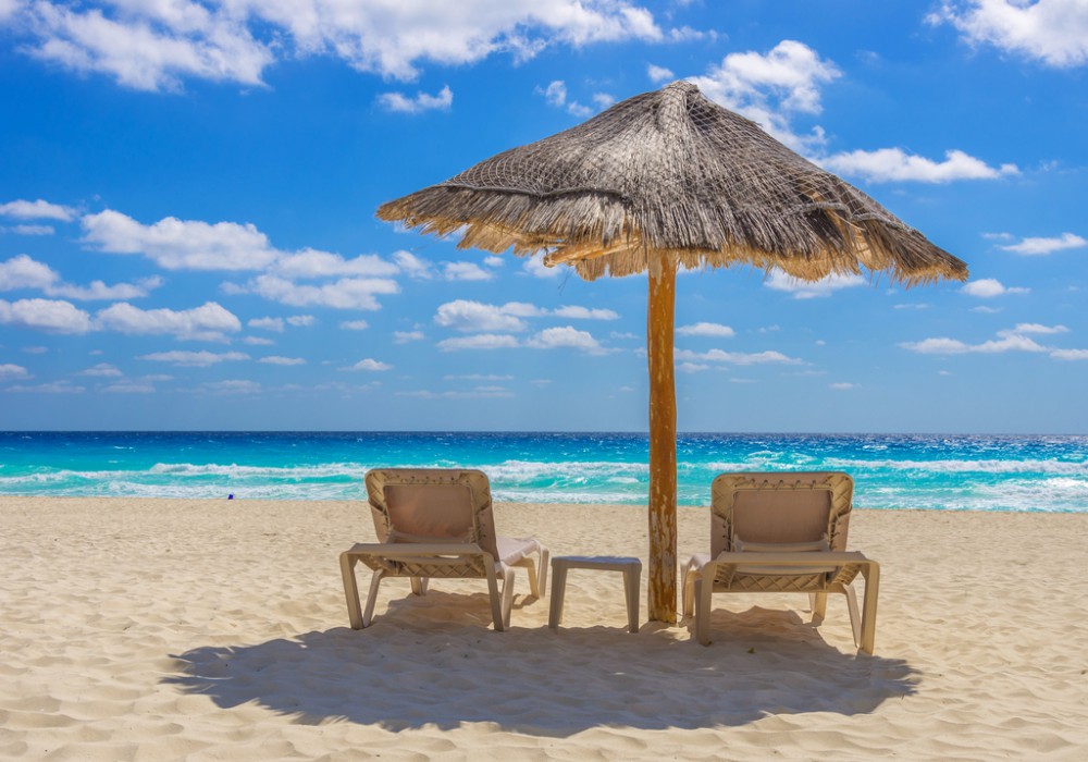 Beach chairs and umbrella on a beautiful tropical island